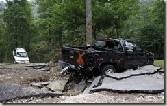 A truck and a van damaged by flash flooding are seen at Albert Pike campground near Caddo Gap, Ark., on Saturday.